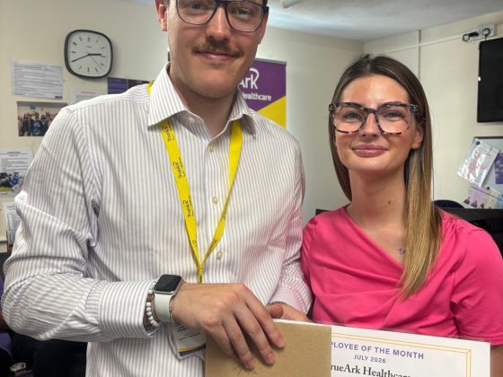 July's employee of the month. Two staff members are standing with a card and certificate.