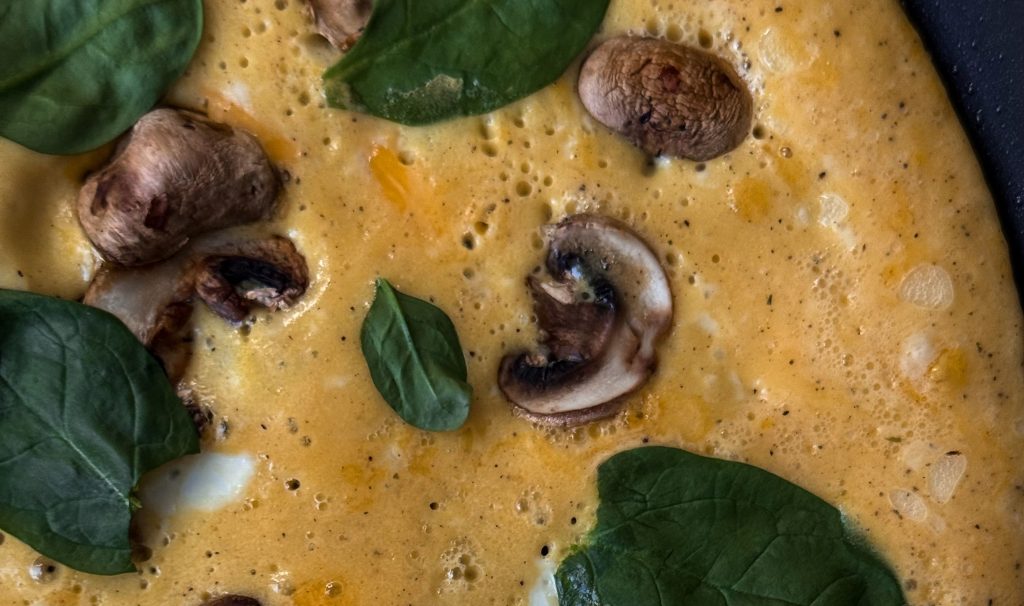 Mushroom and spinach omelette. An image as part of our egg recipe guide. An extreme close up of an omelette with spinach and mushroom on top.